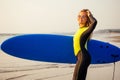 Young freelancing woman in a wetsuit swimming over surfboard in the water at beach.surfer girl relaxing in paradise