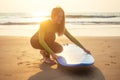 Young freelancing woman in a wetsuit swimming over surfboard in the water at beach.surfer girl relaxing in paradise