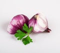 Red flat onion in the skin and half an onion with leaves of fresh young parsley, isolated on a white background