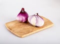 Whole red flat onion and half an onion on a cutting Board, isolated on a white background