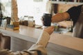 Young friendly barista serving black hot coffee cup to female customer over counter Royalty Free Stock Photo