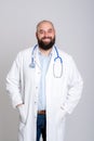 Young friendly and bearded doctor in white coat