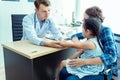 Young friendly caucasian pediatrician doctor is examining child patient girl with her mother ,consultation with a stethoscope and Royalty Free Stock Photo