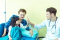 Young friendly caucasian pediatrician male doctor is examining child patient girl with her mother on bed in hospital,consultation Royalty Free Stock Photo