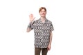 young friendly cute european man with golden hair is dressed in a stylish black and white shirt on a studio background