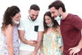 Friendly young man having fun with smartphone - happy group enjoying free time wearing surgical mask Royalty Free Stock Photo