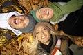 Young friends among autumn leaves smiling Royalty Free Stock Photo