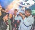 Young friends dancing at party in night club - Diverse culture people enjoying weekend nightlife with original laser lights colors Royalty Free Stock Photo