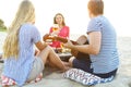 Young friends drinking rose wine on summer beach picnic Royalty Free Stock Photo