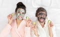 Young friends with facial having fun on bed at pamper party, top view