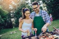 Friends having fun grilling meat enjoying barbecue party Royalty Free Stock Photo