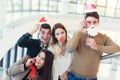 Young friends having fun holding winter artificial mustache