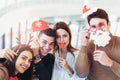 Young friends having fun holding winter artificial mustache