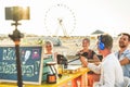 Young friends having fun making live streaming interview to an influencer at beach bar - Man doing video feed using phone camera Royalty Free Stock Photo