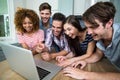 Young friends laughing while looking in laptop on table Royalty Free Stock Photo