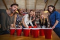 Young friends playing beer pong game in bar Royalty Free Stock Photo