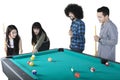 Young friends playing billiard together