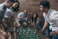 Young friends playing table football together indoors Royalty Free Stock Photo