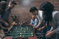 Young friends playing table football together indoors Royalty Free Stock Photo