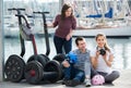 Young friends posing near segways on shore