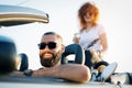 Friends On Road Trip Sitting On Hood Of Convertible Car Royalty Free Stock Photo