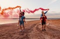 Young friends running with hand flare or fusee Royalty Free Stock Photo