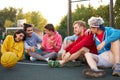 Young friends sitting on basketball court, relaxing and taking break after game