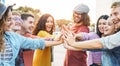 Young friends stacking hands outdoor - Happy millennial people having fun joining and celebrating together