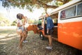 Young friends standing by camper van at campsite