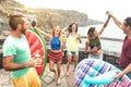 Young friends vacationer having fun at natural pool on travel location - Happy millenial people dancing and drinking cocktails