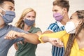 Young friends wearing face mask doing new social distancing greet with elbows bumps for preventing corona virus spread Royalty Free Stock Photo