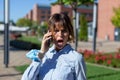 Young frightened businesswoman in park calling by phone