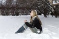 The young frozen woman under the falling snow