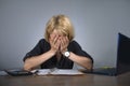 Young frustrated and stressed business woman crying sad at office desk working with laptop computer overwhelmed by paperwork workl Royalty Free Stock Photo