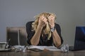 Young frustrated and stressed business woman crying sad at office desk working with laptop computer overwhelmed by paperwork workl Royalty Free Stock Photo