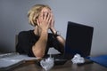 Young frustrated and stressed business woman crying sad at office desk working with laptop computer overwhelmed by paperwork workl Royalty Free Stock Photo