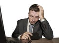 Young frustrated and stressed businessman in suit and tie working overwhelmed at office laptop computer desk desperate and worried Royalty Free Stock Photo