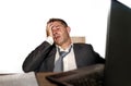 Young frustrated and stressed businessman in suit and tie working overwhelmed at office laptop computer desk desperate and worried Royalty Free Stock Photo