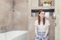 Young frustrated woman looking at a quick positive or negative result pregnancy test sitting in bathroom by a unwanted. Female Royalty Free Stock Photo