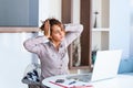 Young frustrated woman working at office desk in front of laptop suffering from chronic daily headaches, treatment online, Royalty Free Stock Photo