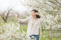 Young fun crazy woman in casual clothes with earphones listening music doing selfie on mobile phone showing victory sign Royalty Free Stock Photo