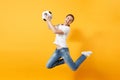 Young fun expressive European woman football fan jumping in air, cheer up support team, holding soccer ball isolated on Royalty Free Stock Photo