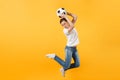 Young fun expressive European woman football fan jumping in air, cheer up support team, holding soccer ball isolated on Royalty Free Stock Photo