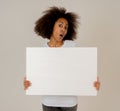 Young funny african american woman holding blank board for advertisement looking excited Royalty Free Stock Photo