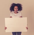 Young funny african american woman holding blank board for advertisement looking excited Royalty Free Stock Photo