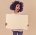 Young funny african american woman holding blank board for advertisement looking excited Royalty Free Stock Photo