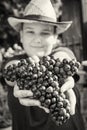 Young funny boy with bunch of grapes in hands, black and white Royalty Free Stock Photo