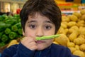 Young funny boy making a funny face. He holds a pod of green peas as a mustache Royalty Free Stock Photo