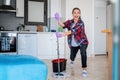 Young funny crazy charming girl woman cleans her apartment with a mop in her hands. House Hygiene and Cleaning Service Concept