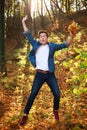 Young funny and curious handsome man jumping in forest park, lifestyle and freedom concept